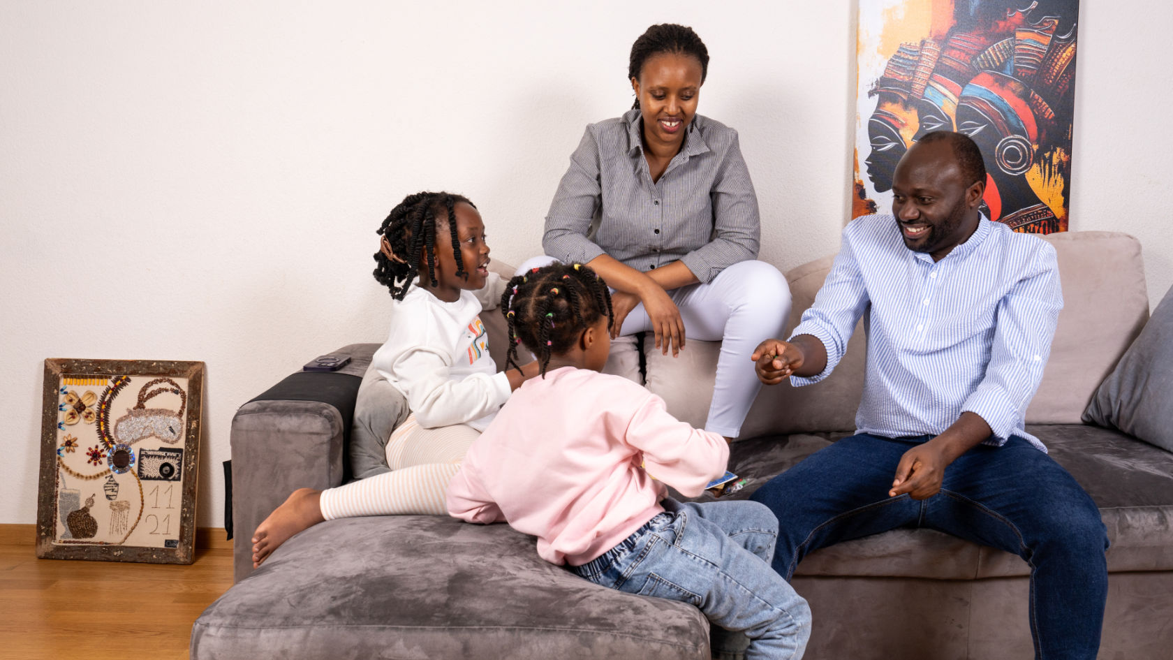 Celestin Mutuyimana mit seiner Familie auf einer grauen Couch