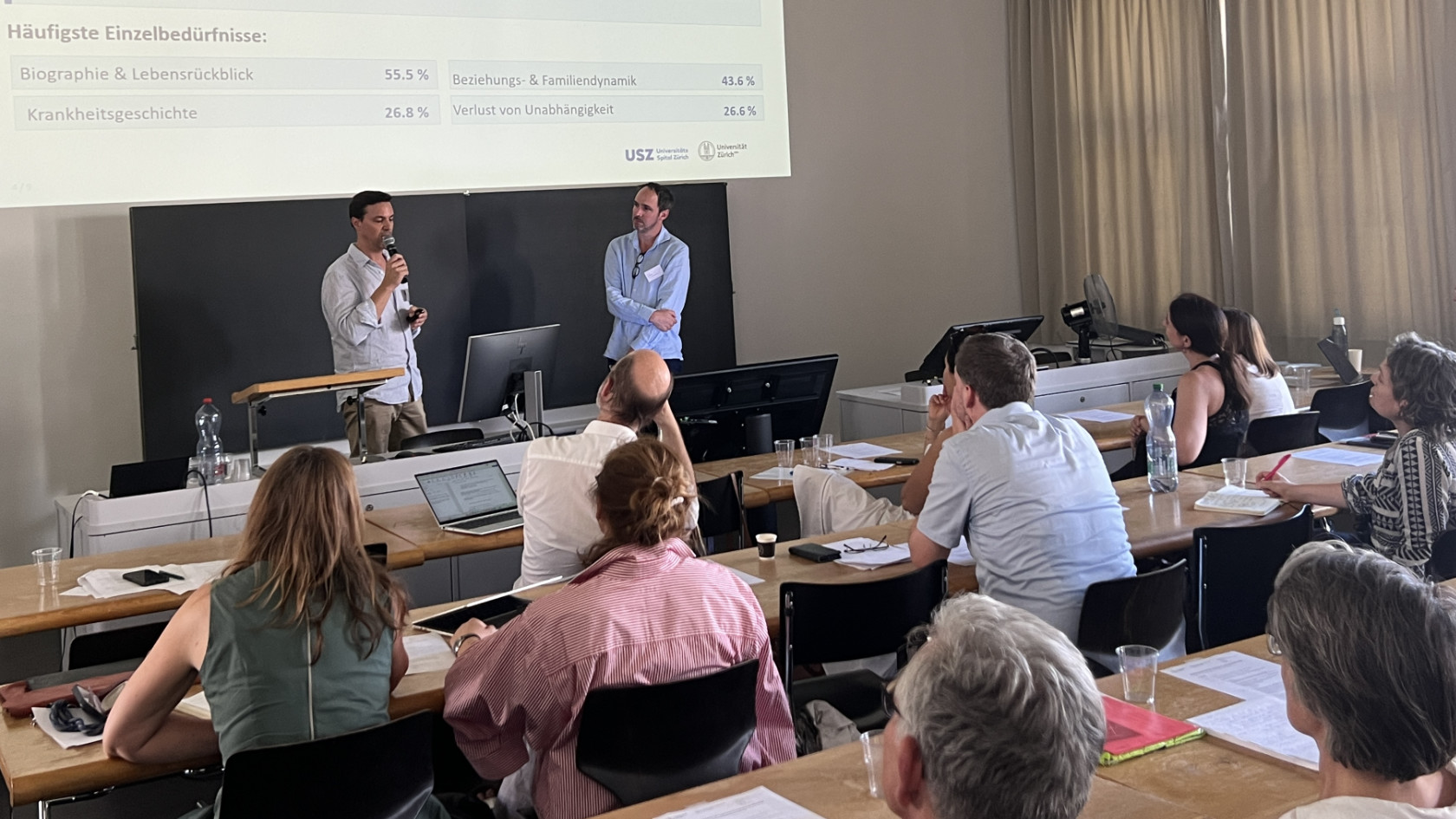 Die Palliativmediziner Markus Schettle und David Blum sprechen vor dem Publikum der Tagung.