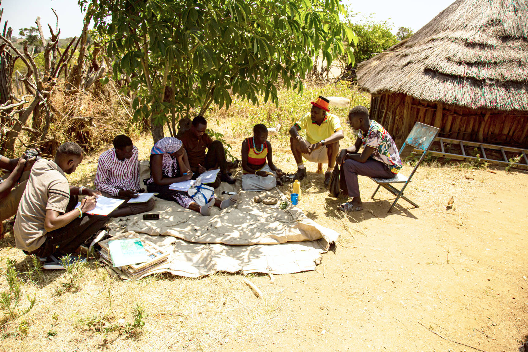 Members of the transdisciplinary research team from Makerere University and the Uganda National Museum doing fieldwork in Kaabong, in northeastern Uganda. They are talking to a local healer and expert in medicinal plants from the Ik tribe about her knowledge of medicinal plants, so they need to work through an interpreter.
